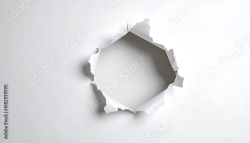 A hole punched through white paper.  Irregular edges