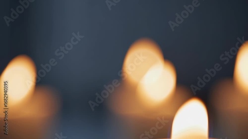 Candles burn softly in the dim light, casting warm, blurred candle glows around. The candles' flames flicker gently, adding a calm atmosphere with candle-lit ambiance.