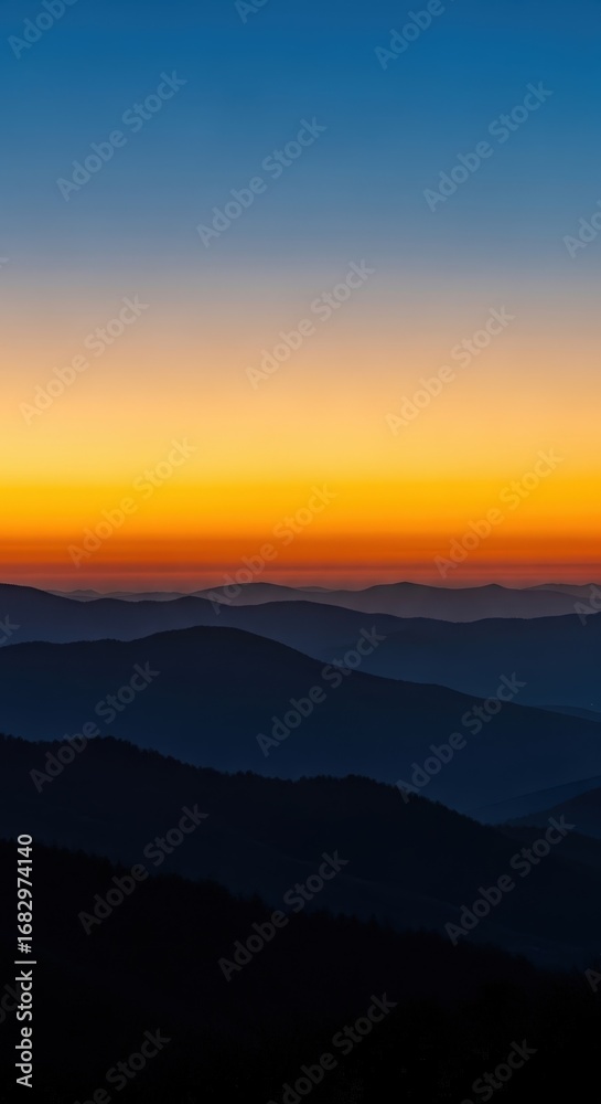 Fototapeta premium Majestic sunset over layered mountain peaks with soft gradient sky