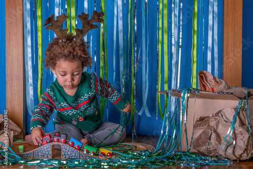 Obraz na plátne Toddler plays with a train set at a Christmas party