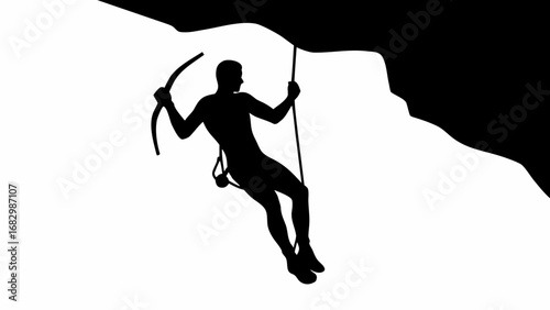 Silhouette of a rock climber hanging from a rope with an ice axe on a rock face in black and white