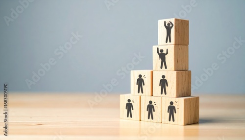 Stacked wooden blocks display simple human icons in ascending order, symbolizing progress and achievement against a plain background and light wood surface