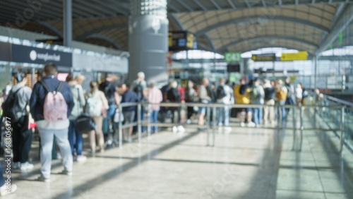 Fotografija Crowd at airport terminal one with defocused people in blurred background and bokeh effect showcasing busy travel scene with diverse passengers waiting in queue