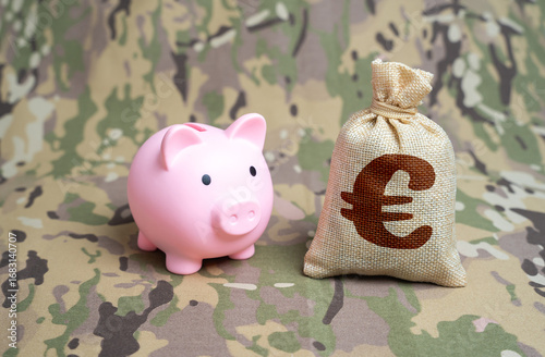 Obraz na płótnie Piggy bank and euro money bag on military background