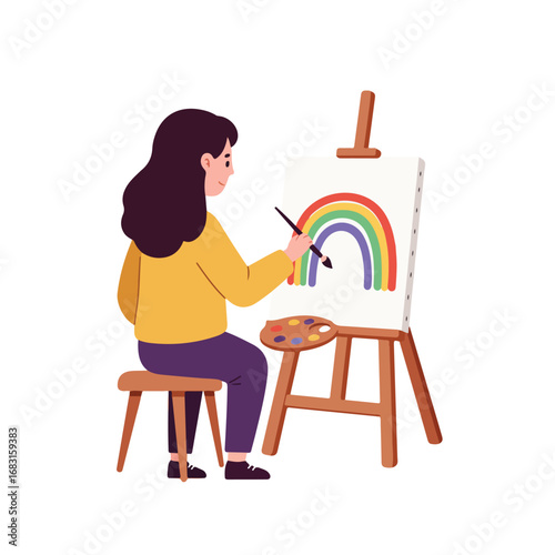 A person sits on a stool painting a rainbow on a canvas supported by an easel