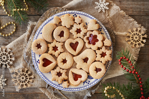 Linzer Christmas cookies filled with marmalade and dusted with sugar on a plate, top view