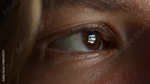 Teen scrolling through online videos. Extreme macro eye close-up with laptop screen reflection. Technological and Social Media.
