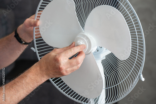 A man assembles a floor fan at home