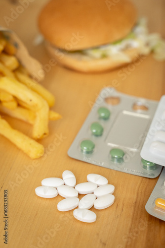 Fries and medical pills. Junk food and health concept