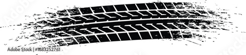 Black tire track impression shows tread pattern amid spray of dirt
