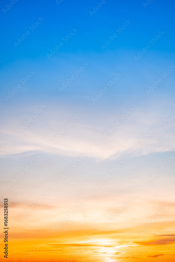 Naklejka premium Beautiful , luxury soft gradient orange gold clouds and sunlight on the blue sky perfect for the background, take in evening,Twilight, Large size, high definition landscape photo,Vertical