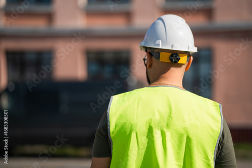 Builder's back in helmet and signal vest