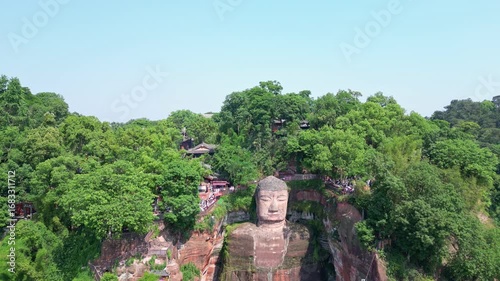 Leshan, China: Aerial drone footage of the famous Leshan giant Buddha stone statue  at the confluence of the Min River and Dadu River in Sichuan in China. Shot with a downward motion