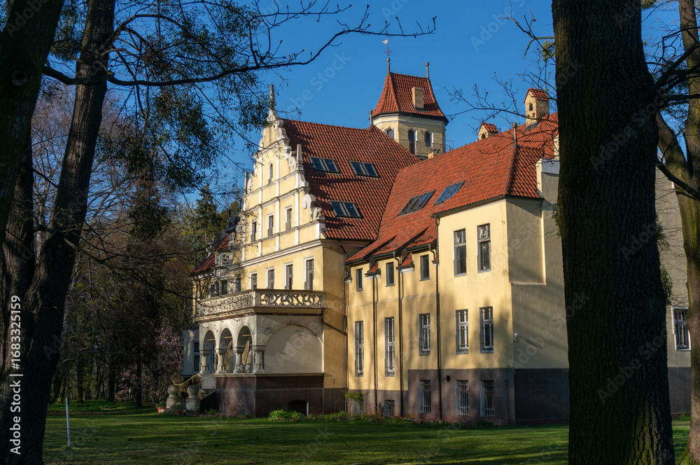 Obraz premium Eclectic palace with features of Northern Neo-Renaissance style is situated in historic park. Multi-pitched roof covered with ceramic tiles. Ornontowice (village, Silesian Voivodeship), Poland.