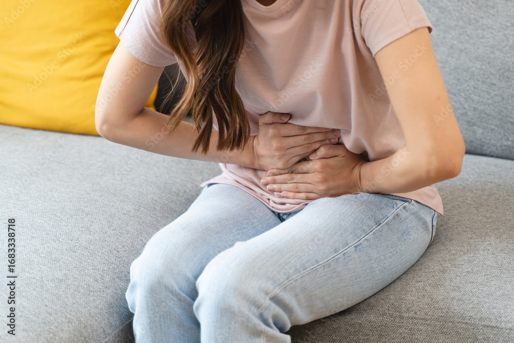 Fototapeta premium person feeling stomach pain menstruation on the bed.
