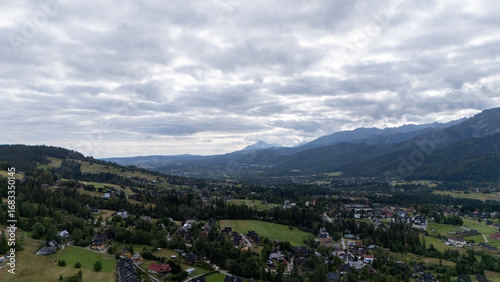 Fototapeta Naklejka Na Ścianę i Meble -  Mountain peaks near Zakopane, Poland, in summer. Lush green landscape with drifting clouds over alpine scenery. Ideal for nature, travel and outdoor visuals