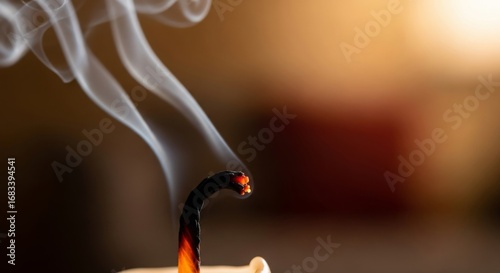 Smoldering candle wick with delicate wisps of smoke creating a calming and reflective mood