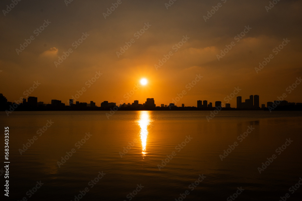 Golden sunset over the lake, silhouetted friends watching the glowing horizon in peaceful harmony. Golden sunset over the lake, silhouetted friends watching the glowing horizon in peaceful harmony.