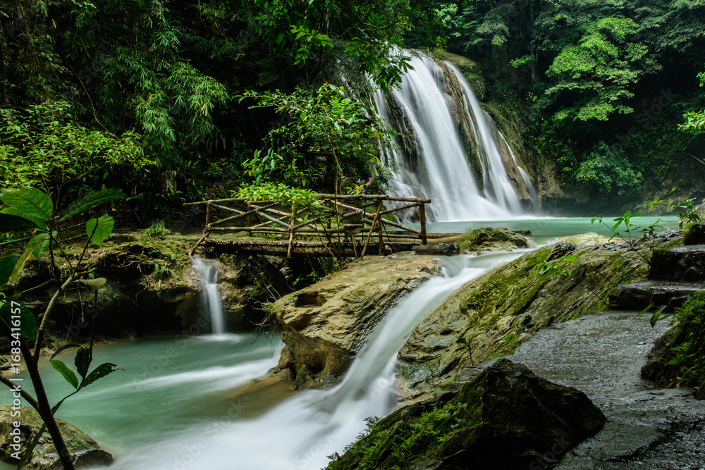 Obraz premium Daranak Falls with Wooden Bridge in Lush Jungle in Tanay, Rizal, Philippines, taken last 2017
