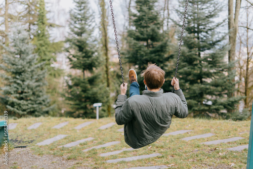 A man swinging alone in the park