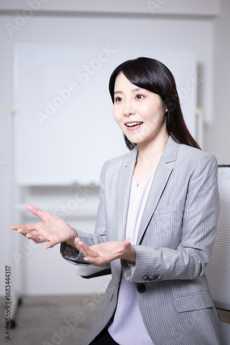 ホワイトボードの前でインタビューに応える女性6