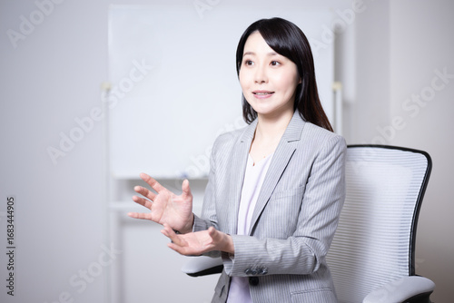 ホワイトボードの前でインタビューに応える女性11
