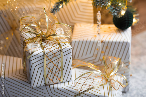 New Year's Eve, cozy concept for the Christmas holidays Stylish gift boxes on the background of a Christmas tree in the home interior of the living room. We are preparing gifts for our loved ones.
