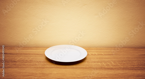 Weisser Essteller auf einem Holztisch vor heller Wand