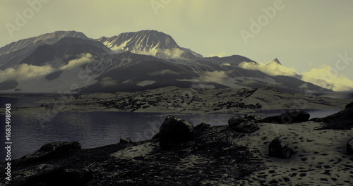 Картината върху платно A vast mountain range looms over a calm lake, reflecting soft twilight colors
