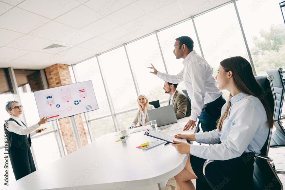 Fototapeta premium Diverse Group of Business Professionals Discussing Project Strategies in a Modern Office Setting