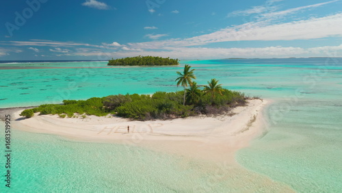 Fényképezés Aerial drone image of a castaway writing help in the sand while standing on a be