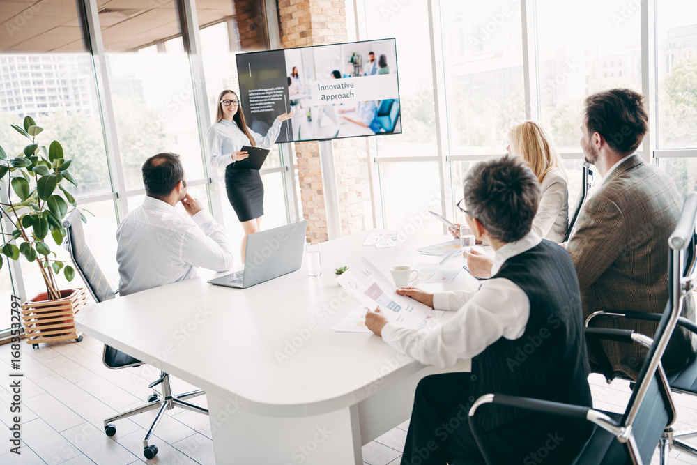 Fototapeta premium Business team collaborating during a presentation in a modern office, discussing innovative concepts and strategies