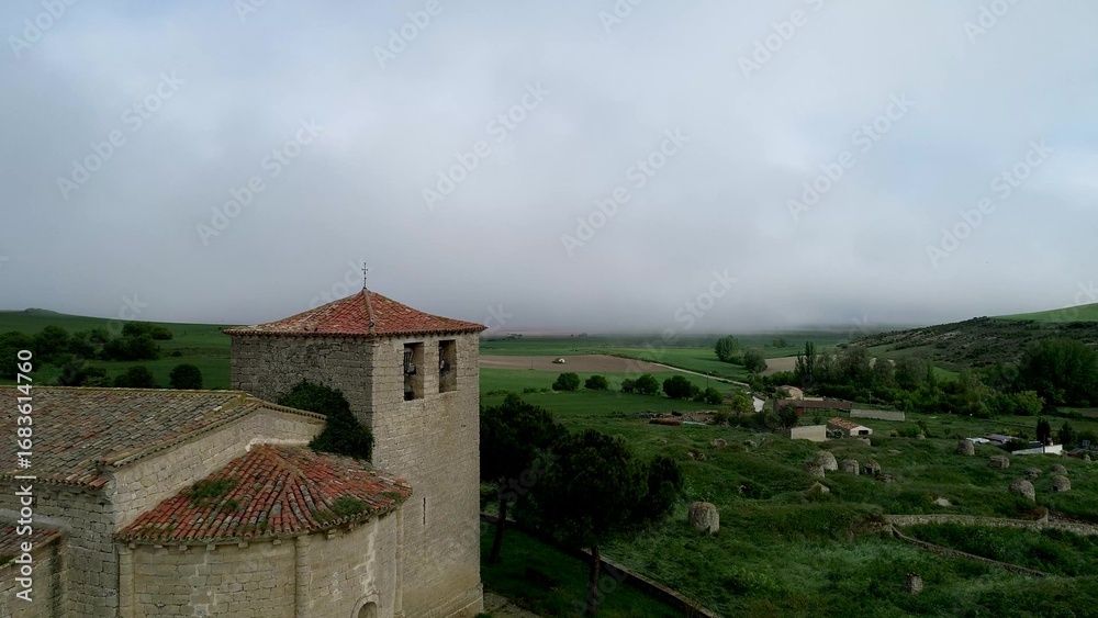 Fototapeta premium Bell tower of Iglesia de San Fructuoso in Valoria del Alcor Palencia under misty sky