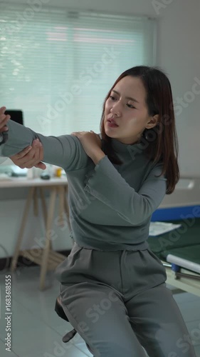Female patient experiencing intense shoulder pain during detailed medical examination, healthcare professional assessing joint condition in clinical setting