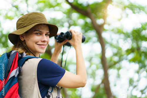 Canvas Print Asian - caucasian woman birdwatching with binoculars and notebook, studying nature