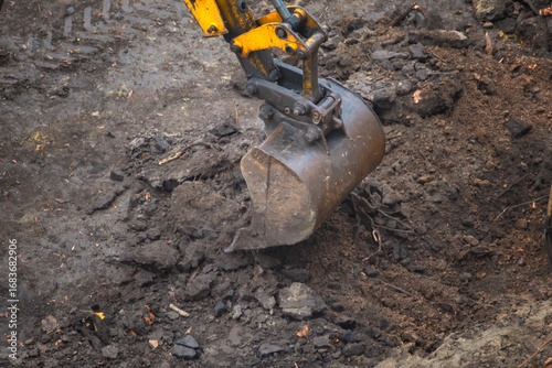 Wallpaper Mural Excavator bucket digs wet moist soil close-up, excavator bucket excavates earth at construction site, start of construction work, excavator begins digging foundation pit. Torontodigital.ca