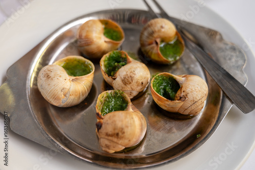 Oven baked snails with parsley garlic butter from Burgundy served as basic starter dish in French restaurant bouillon in Toulouse or Paris