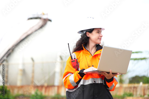 Environmental engineer or ecological scientist industrial worker in safety uniform working for inspect water quality at industry construction site near oil refinery plant by the sea.