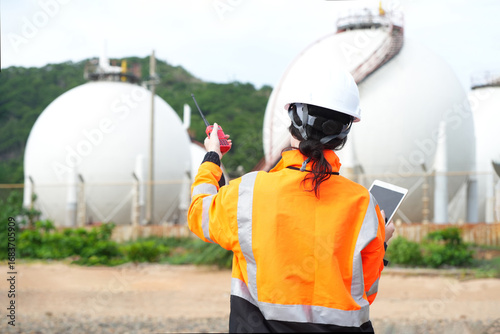 Environmental engineer or ecological scientist industrial worker in safety uniform working for inspect water quality at industry construction site near oil refinery plant by the sea.