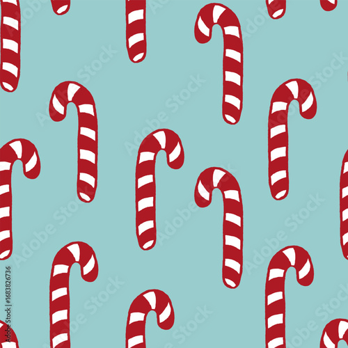 Vector seamless pattern with freehand drawn cartoon sugar candy canes on blue background