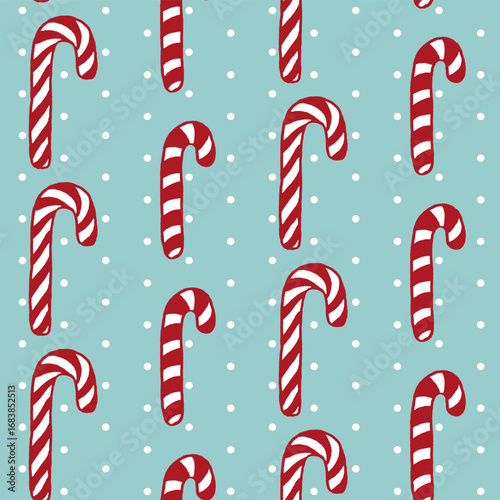Vector seamless pattern with freehand drawn cartoon sugar candy canes on blue background with polka dots