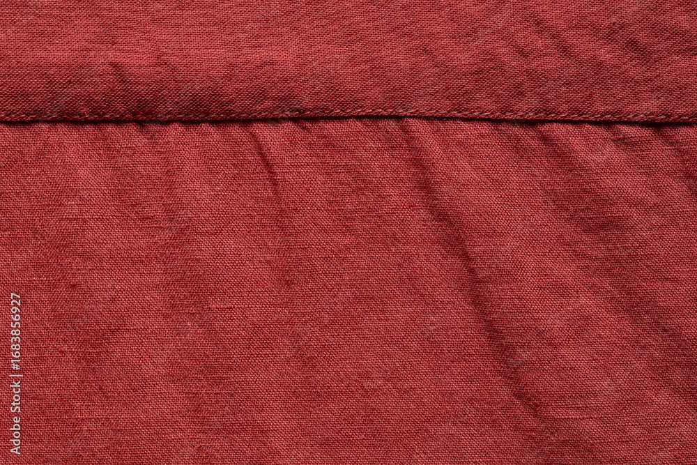 Fototapeta premium Red linen fabric texture with horizontal stitching close-up as background or wallpaper