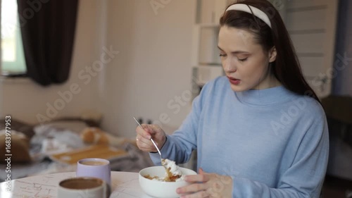 a young woman having breakfast at home at the table