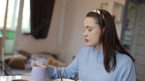 a young woman having breakfast at home at the table