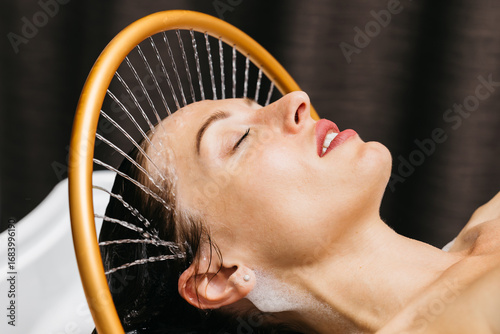 Photography Woman enjoying hydromassage therapy in a serene spa environment, water cascading