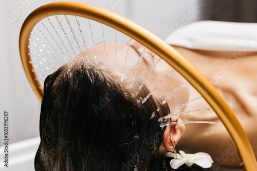 Slika na platnu Woman receiving hydromassage therapy with gentle water jets, relaxing in a seren