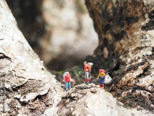 Mini toy of action figure at outdoor with blurred background. Miniature photography concept design. Minifigure of traveler character with tent at camping ground. Holiday, vacation and traveling.