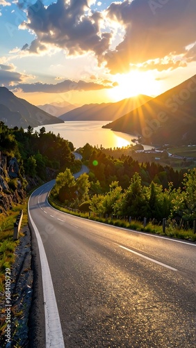 Scenic winding road at sunset over a lake