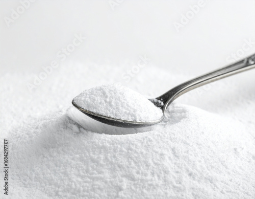 A spoonful of powdered sugar on a pile of powdered sugar