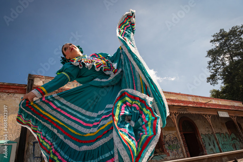Canvas Print Mexican folk dancer performing in turquoise traditional dress with colorful ribb